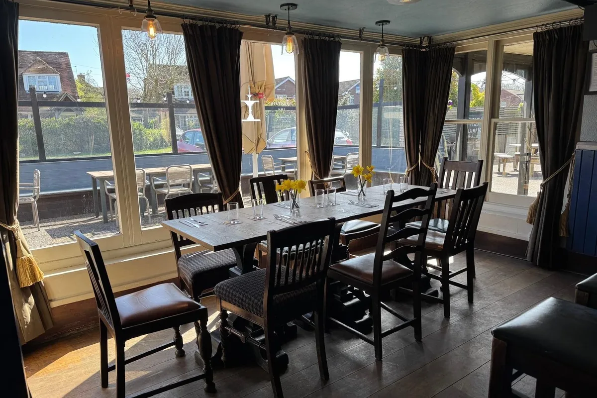 The dining room laid up for a party, with a long table and windows onto the terrace